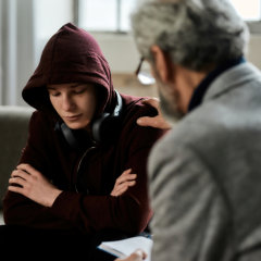 boy wearing jacket and a professional talking