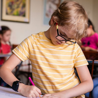 boy with glassess drawing